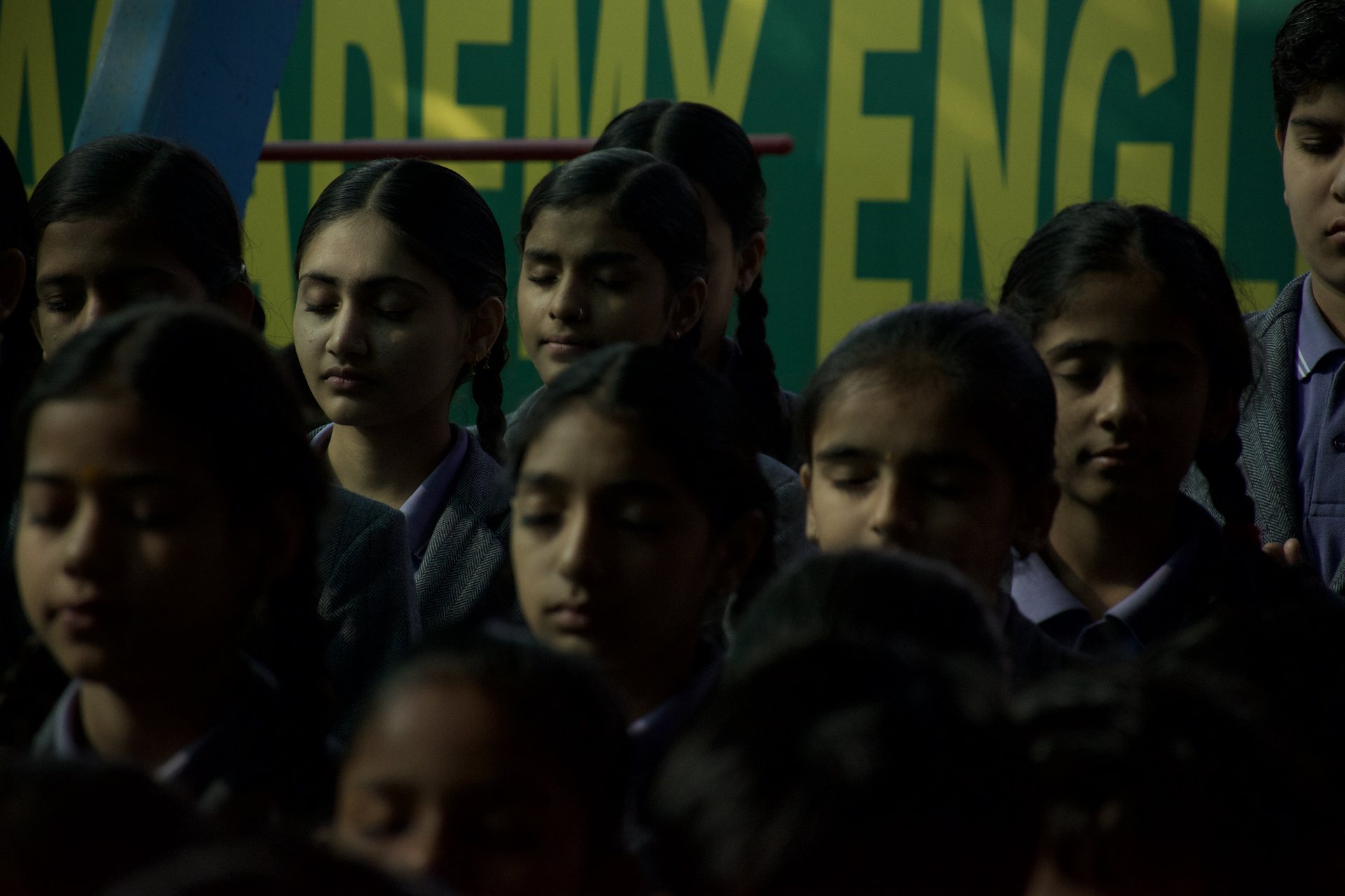 Students with eyes closed during morning prayer